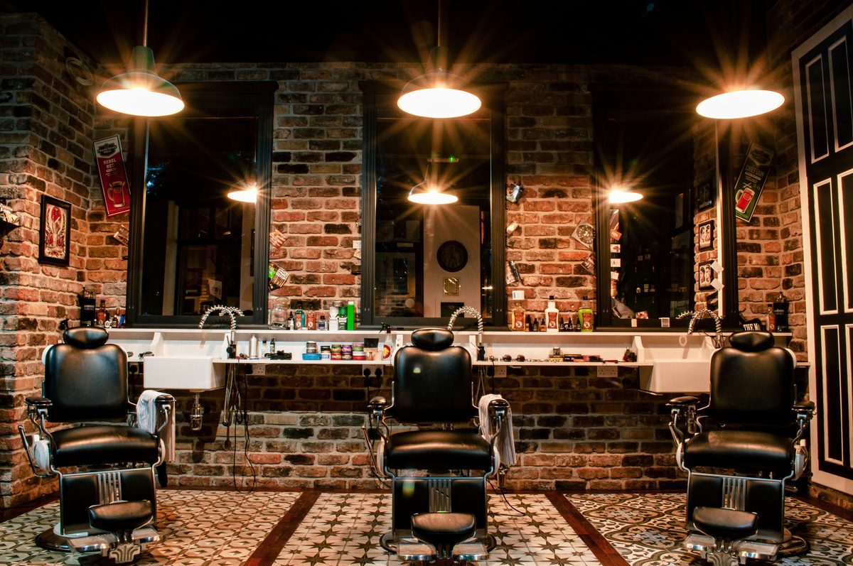 Intérieur du salon : trois fauteuils de barbier devant les miroirs