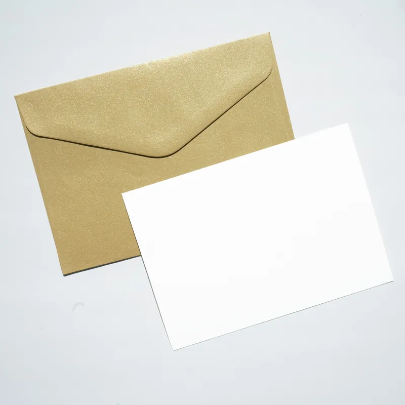 Carte blanche posée sur une enveloppe dorée